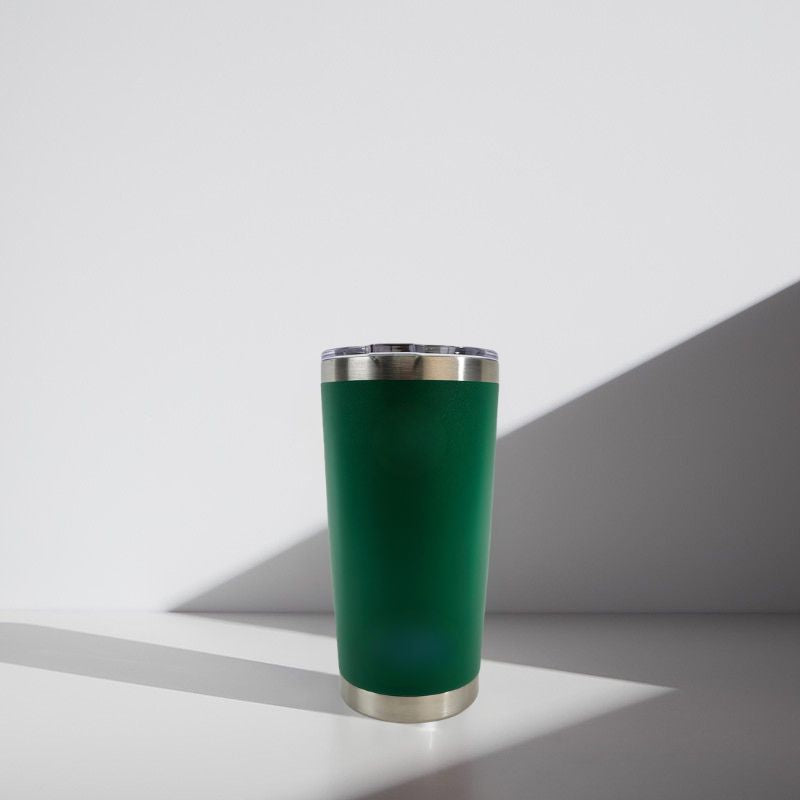 Green tumbler with silver rim on a white background