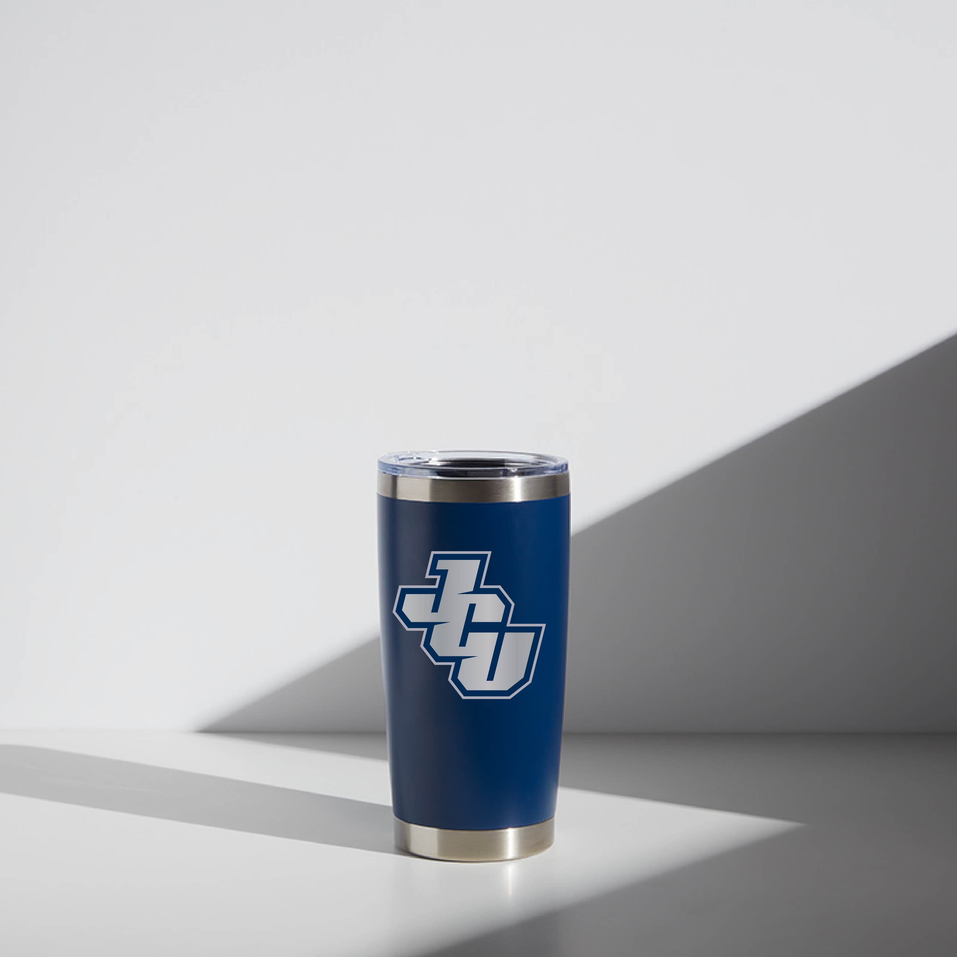 20 oz blue WATR tumbler with John Carroll University JCU logo, placed on a surface under soft lighting.