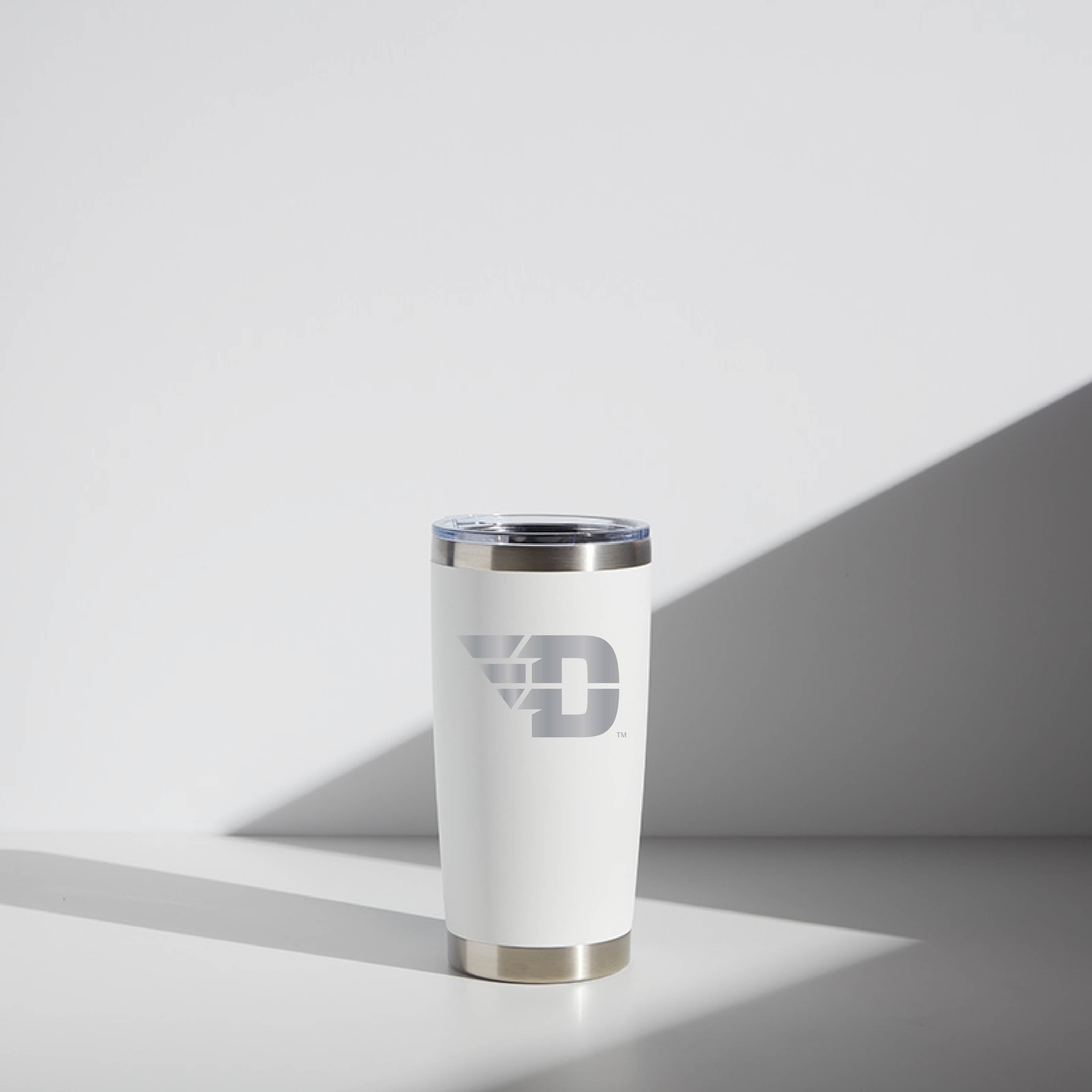 Alt text: "20 oz WATR Tumbler featuring the Dayton 'Flying D' logo in silver on a white background, stainless steel rim and base, sitting in a subtly lit environment."