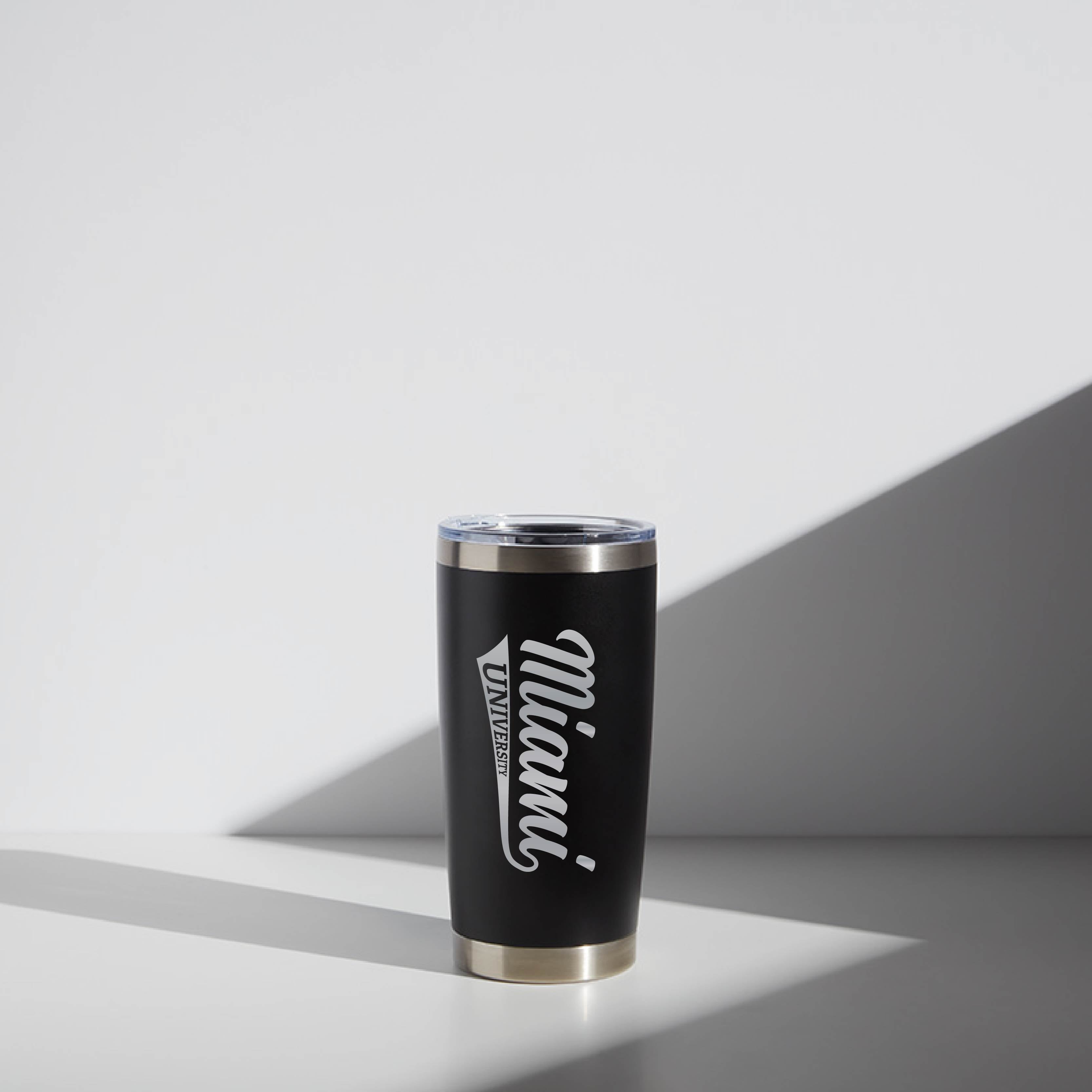 Black 20 oz WATR tumbler with Miami University script logo, placed on a light surface with shadow lines.