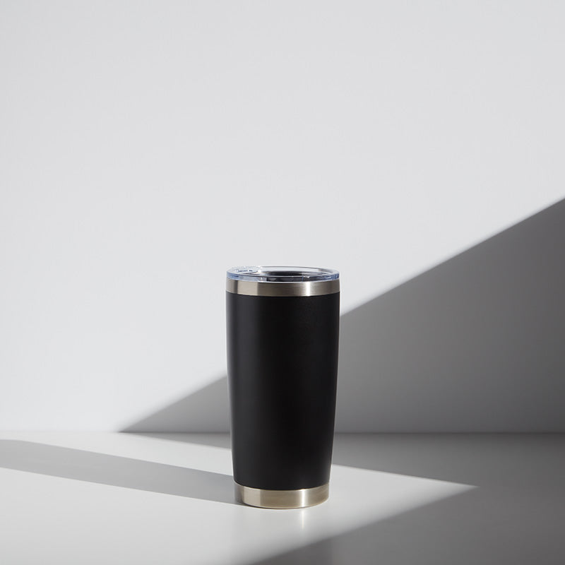20 oz black stainless steel tumbler with a clear lid and gold base, suitable for personalized teacher gifts, displayed on a light gray background with shadows.