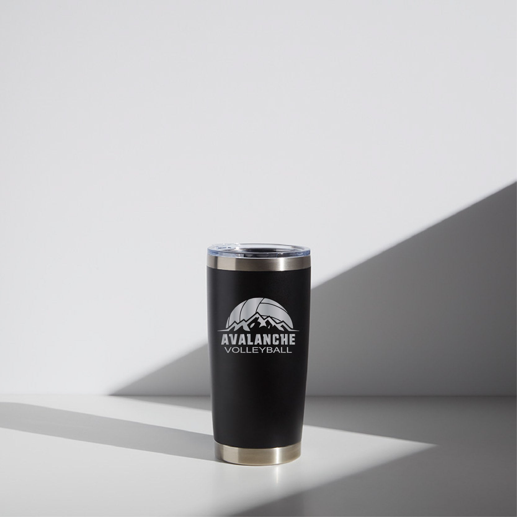 Stainless steel 20 oz tumbler with black finish featuring the "Avalanche Volleyball" logo in white on a minimalist background with angled shadowing.