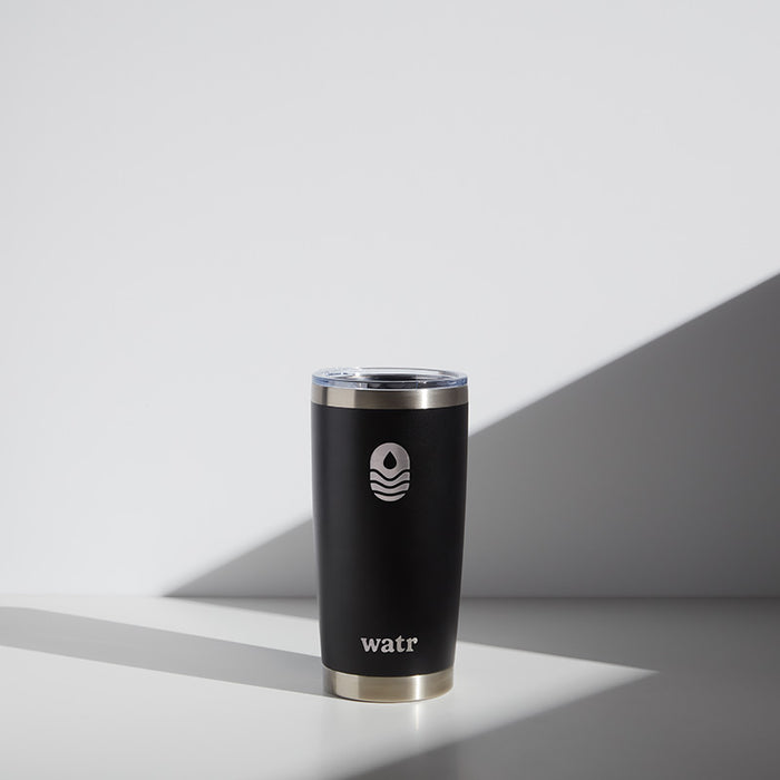 Alt text: "Black 20 oz WATR Tumbler with silver rim, featuring the Manta United Soccer logo in white, positioned on a light grey surface with a soft shadow."