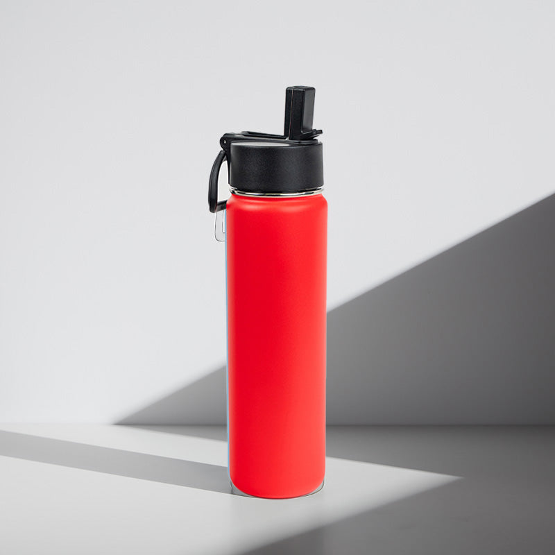 Red water bottle with black lid on a gray background