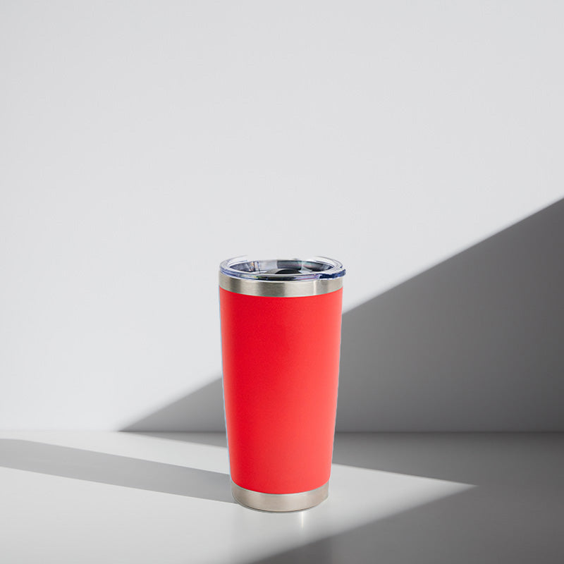 Red tumbler with silver rim on a light gray background